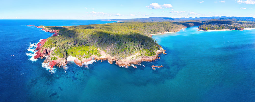 Red rocks around the forested headland of Haycock Point near Pambula, New South Wales - fine art photography print by Adam Gormley