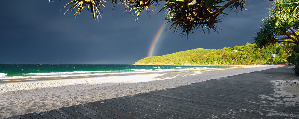 Rainbow over storm clouds at Noosa Main Beach, Sunshine Coast, Queensland - fine art photography print by Adam Gormley