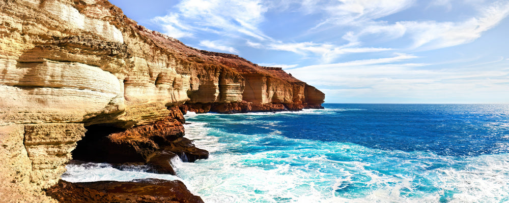 Sandstone cliffs and blue surf at Red Bluff, Quobba Station, Western Australia - fine art photography print by Adam Gormley