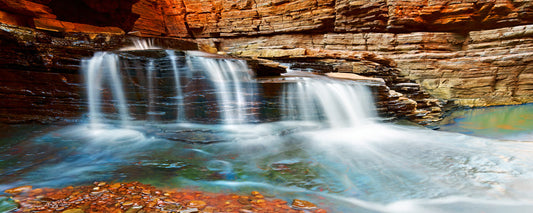 Silky water spilling over rock ledges in Hancock Gorge, Karijini National Park - photography by Adam Gormley