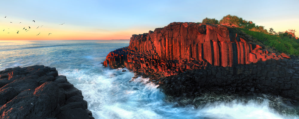 Red basalt columns glowing at sunset at Fingal Head, Tweed Coast, New South Wales - fine art photography print by Adam Gormley