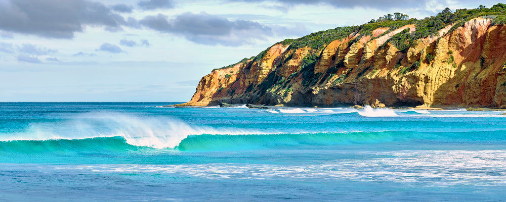 Turquoise wave rolling in below golden cliffs in Great Otway National Park, Victoria - fine art photography print by Adam Gormley