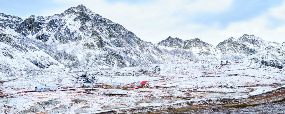 Old Independence Mine in a snowy valley below the peaks of Hatcher Pass, Alaska - fine art photography print by Adam Gormley