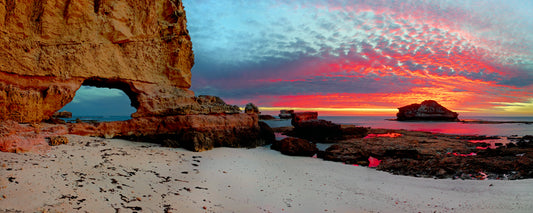 Red sunset sky over a rock arch on the beach, Mornington Peninsula, Victoria - fine art photography print by Adam Gormley