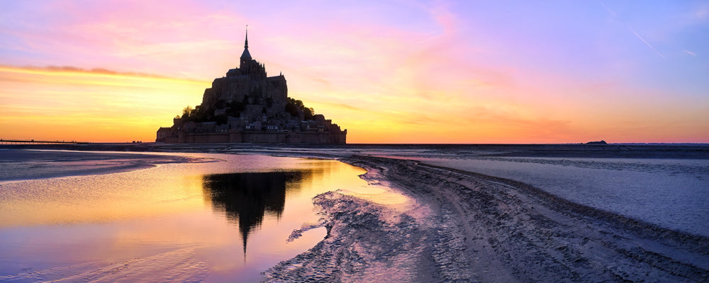 Mont-Saint-Michel silhouetted against a pink and orange sunset, Normandy, France - fine art photography print by Adam Gormley