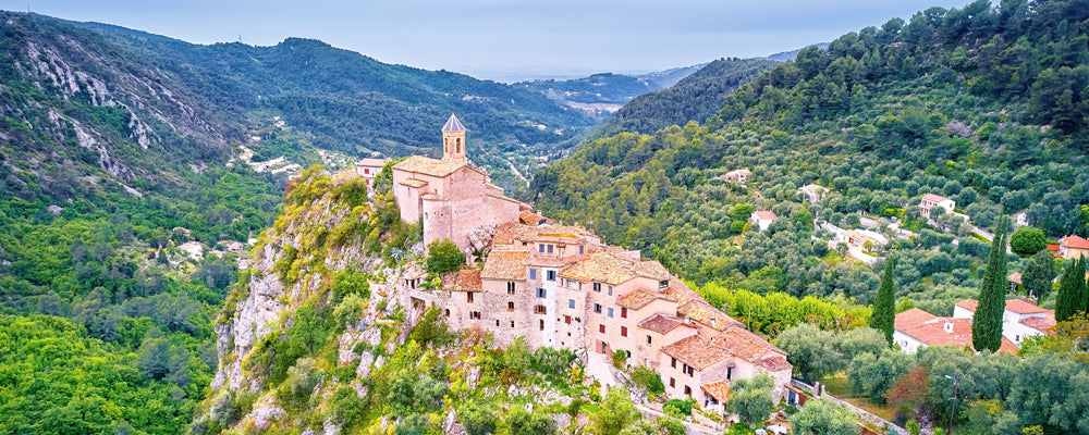 Hilltop village of Peillon on a rocky ridge above green valleys, France - fine art photography print by Adam Gormley