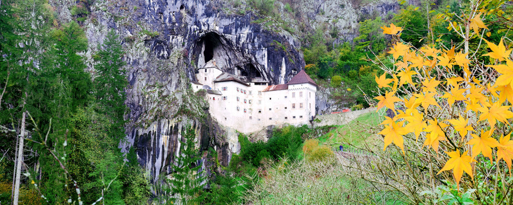 Predjama Castle built into a cave in a limestone cliff, Slovenia - fine art photography print by Adam Gormley