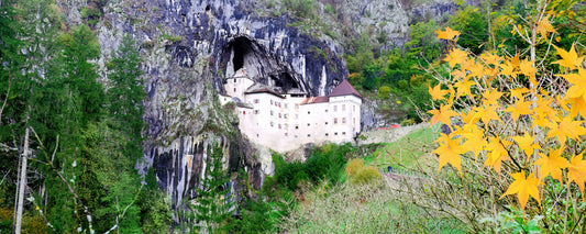 Predjama Castle built into a cave in a limestone cliff, Slovenia - fine art photography print by Adam Gormley