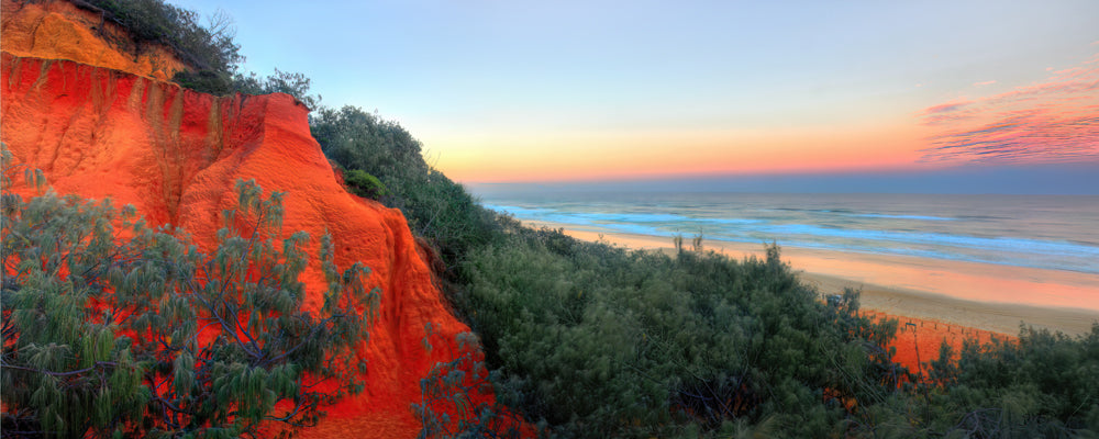 Red sand cliffs glowing at sunrise above the beach, Red Canyon, K'gari (Fraser Island), Queensland - fine art photography print by Adam Gormley