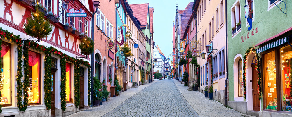 Christmas garlands and lights along a cobbled street in Rothenburg, Germany - fine art photography print by Adam Gormley