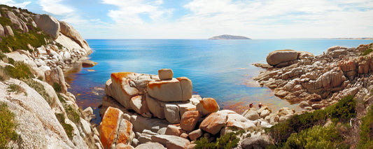 Orange lichen-covered granite boulders above clear water at Tongue Point, Victoria - fine art photography print by Adam Gormley