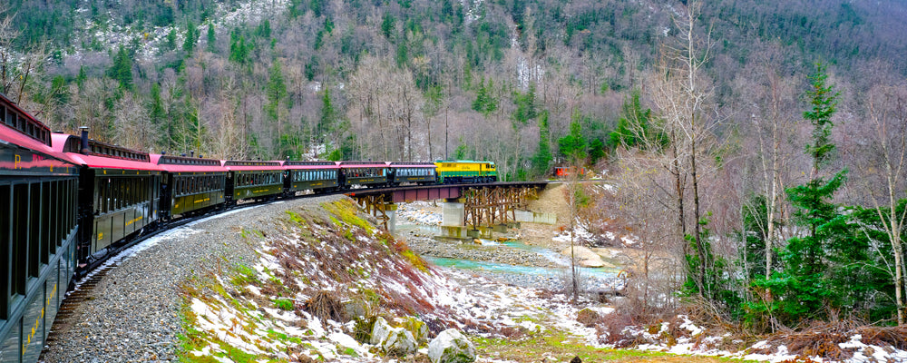 Vintage carriages of the White Pass railway curving through forest near Skagway, Alaska - fine art photography print by Adam Gormley